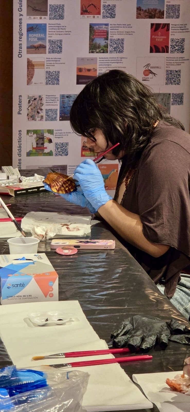 Estudiante trabaja sobre una mesa con materiales de curaduría paleontológica